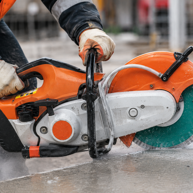 Construction operative cutting stone with saw